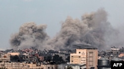 O fotografie realizată din Rafah, în sudul Fâșiei Gaza, arată fumul care se ridică deasupra clădirilor din Khan Yunis, în depărtare, în urma bombardamentelor israeliene din 5 februarie 2024, în timp ce luptele dintre Israel și gruparea palestiniană Hamas continuă.