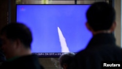 Njerëzit në Korenë e Jugut duke shikuar lajmet për lëshimin e një rakete balistike nga Veriu në tetor të vitit 2025. 