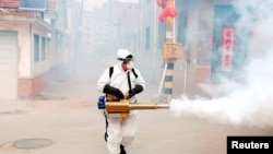 Работник дезинфекцира улиците на китайски град в провинция Шандун