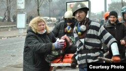 Розстріли на Майдані у Києві 20 лютого 2014 року. Марія Матвіїв намагається врятувати пораненого 19-річного студента Романа Гурника