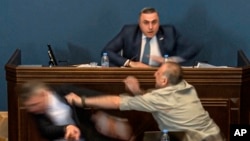 Алеко Элисашвили, который молча наблюдал за дебатами, подошел к трибуне и нанес прямой удар в голову Мамуке Мдинарадзе