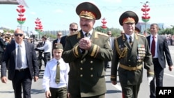 Президент Білорусі Олександр Лукашенко у супроводі свого тоді ще маленького сина Колі на параді до Дня незалежності у Мінську, 3 липня 2013 року