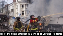 Пожарные работают на месте российского ракетного удара в центре Сум, Украина, 13 апреля 2025 года