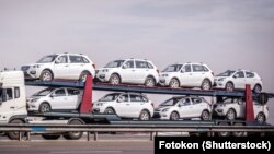 Жеңил машинелерди ташыган оор жүк машине. Иллюстрациялык сүрөт.