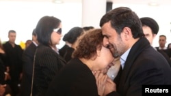 Ahmadinejad shihet duke i mbajtur duart Elena Friasit, nënës së Chavezit.