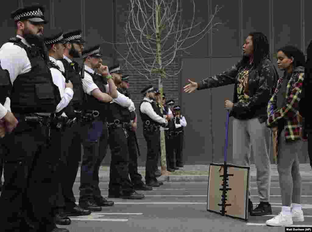 Një protestuese shihet duke iu afruar zyrtarëve policorë afër ambasadës amerikane në Londër, gjatë protestave të 3 qershorit.