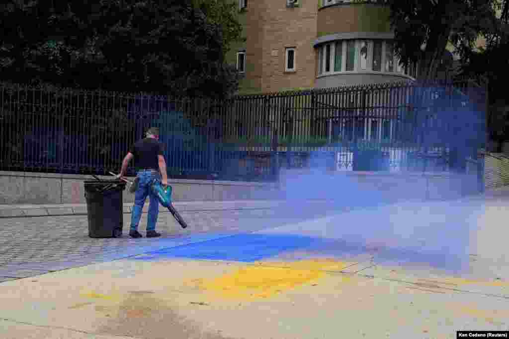 Серпень 2025 року. Чоловік прибирає залишки фарби в кольорах українського прапора з тротуару біля російського посольства у Вашингтоні, США