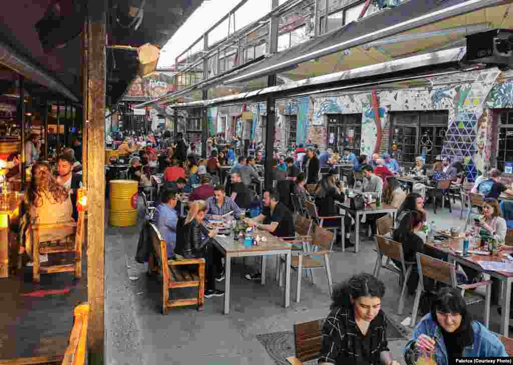 Oamenii peterec seara la terasa Fabrica Pub din București.