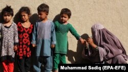 FILE: A health worker marks the little finger of a child after administering polio vaccination to children in Kandahar on April 1.