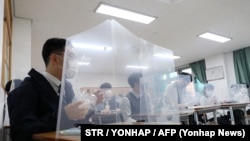 Cтуденти за захисним щитом під час поновлення навчання в Південній Кореї