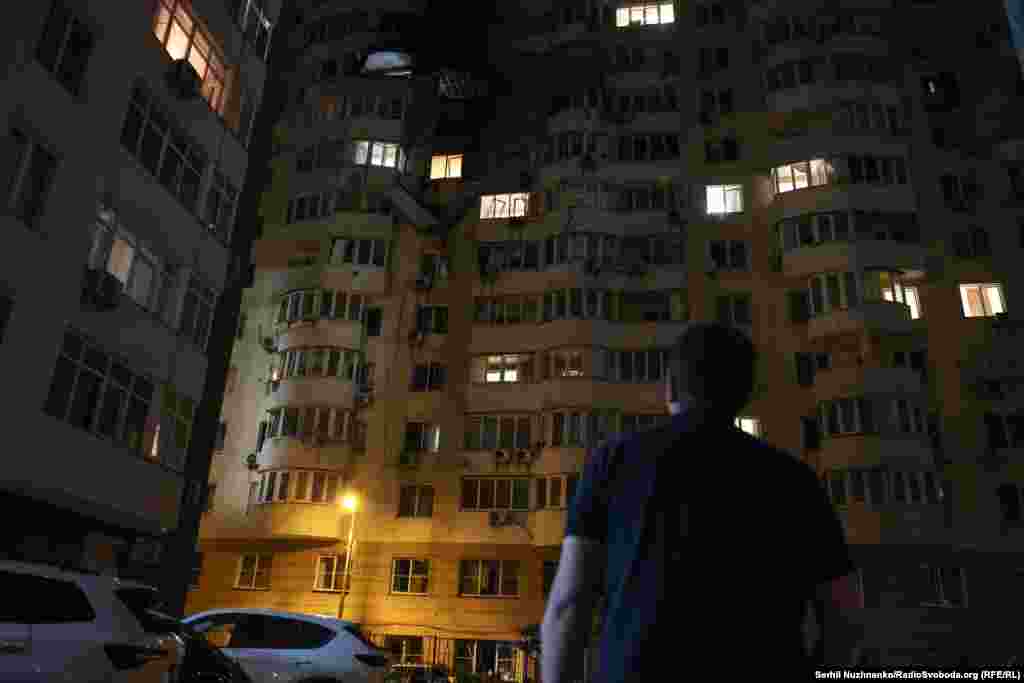 Киянин оглядає будинок, що зазнав ушкоджень під час масованої російської ракетно-дронової атаки по Києву