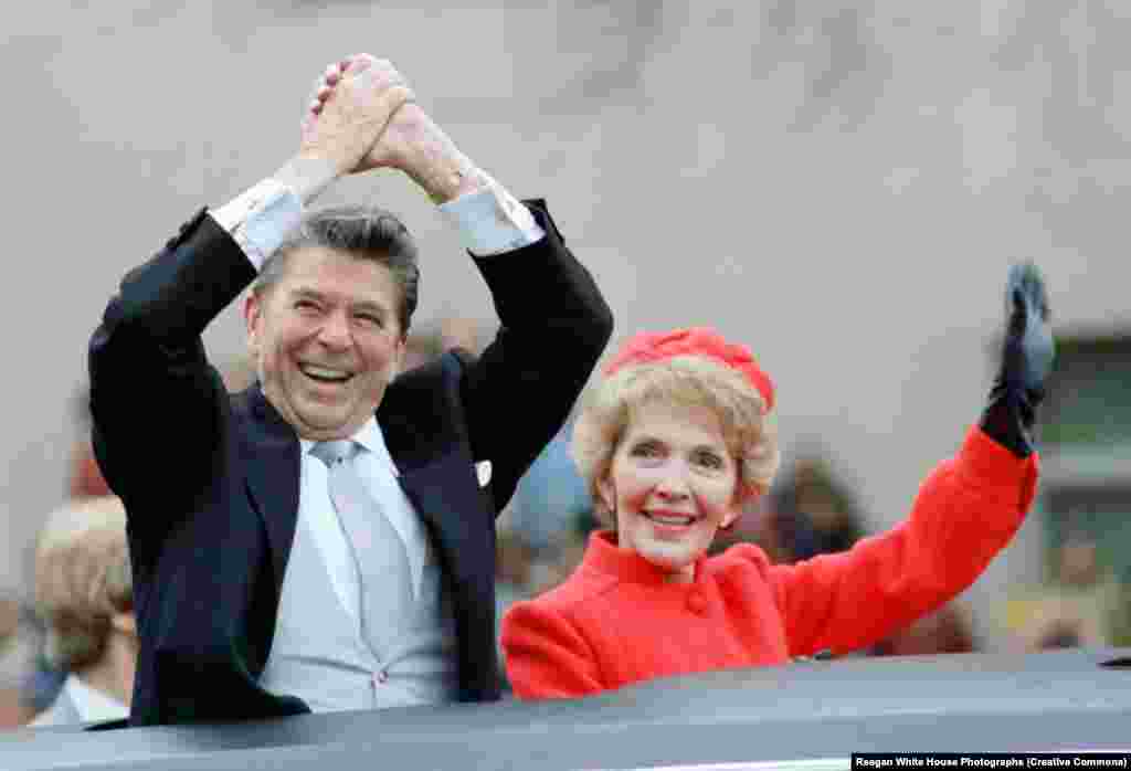 Președintele Ronald Reagan și prima doamnă Nancy salută din limuzină în timpul paradei de învestire din 20 ianuarie 1981. Reagan a avut două mandate.