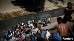 Электр кубаты жок Каракастын жашоочулары саркынды суу аккан каналдан суу алып жатышат. 11-март, 2019-жыл. 