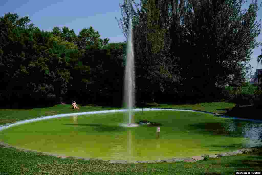 Човек седи покрај фонтана во А Коруња, Шпанија, на 29 јуни.