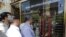 Iranians check exchange rates outside a bank in Tehran. The country's currency, the rial, has lost 70 percent of its value in recent years, causing much economic hardship. (file photo)