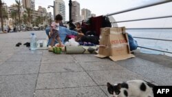 O familie de libanezi care s-a refugiat pe faleza Beirutului după atacurile israeliene asupra capitalei Libanului.