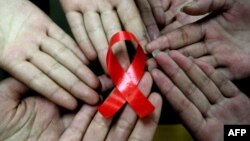 Сүрөттөгүдөй кызыл тасма СПИДге каршы күрөштүн белгиси катары колдонулат. 