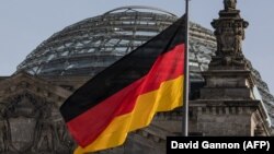 Флаг Германии у здания Рейхстага в Берлине