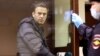 Russian opposition leader Aleksei Navalny, charged with defaming a World War II veteran, looks out from inside a glass cell during a court hearing in Moscow on February 5.