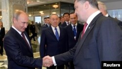 Russian President Vladimir Putin (left) shakes hands with Ukrainian President Petro Poroshenko ahead of talks in Minsk on August 26.