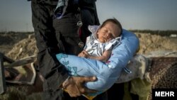 نوزادی که در کنار اتوبانی در حاشیه تهران به دنیا آمده، در آغوش مادر معتادش