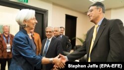 FILE: International Monetary Fund Managing Director Christine Lagarde (L) greets former Pakistani Finance Minister Asad Umar at the Bali Convention Centre during the 2018 IMF/World Bank Annual Meetings.