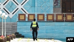 Policajac ispred "Plave džamije", u kojoj se nalazi Islamski centar Hamburga, nakon višemjesečne istrage zbog navodne podrške libanskom Hezbolahu, jul 2024