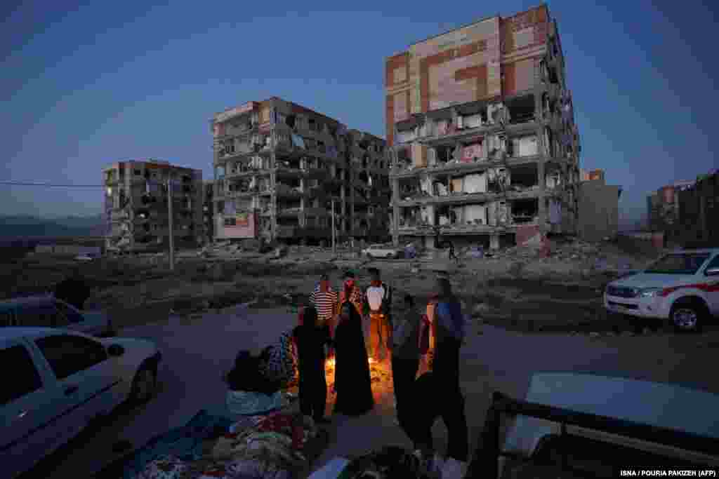 Residents huddle by a fire in an open area in Sarpol-e Zahab.