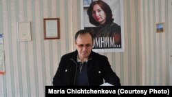 Оюб Тітієв у приміщенні чеченського «Меморіалу» у Грозному на тлі портрету своєї вбитої колеги Наталії Естемірової, архівне фото