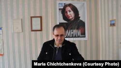 Оюб Тітієв у приміщенні чеченського «Меморіалу» у Грозному на тлі портрету своєї вбитої колеги Наталії Естемірової, архівне фото