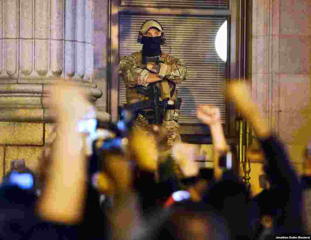 Öklüket emelik a magasba ezek a tüntetők Észak-Karolinában, miközben egy felvegyverzett őr áll a megyei bíróság épülete előtt.