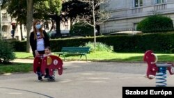 Fiatal filippínó dada Párizs egyik játszóterén kisgyerekkel 2021 májusában