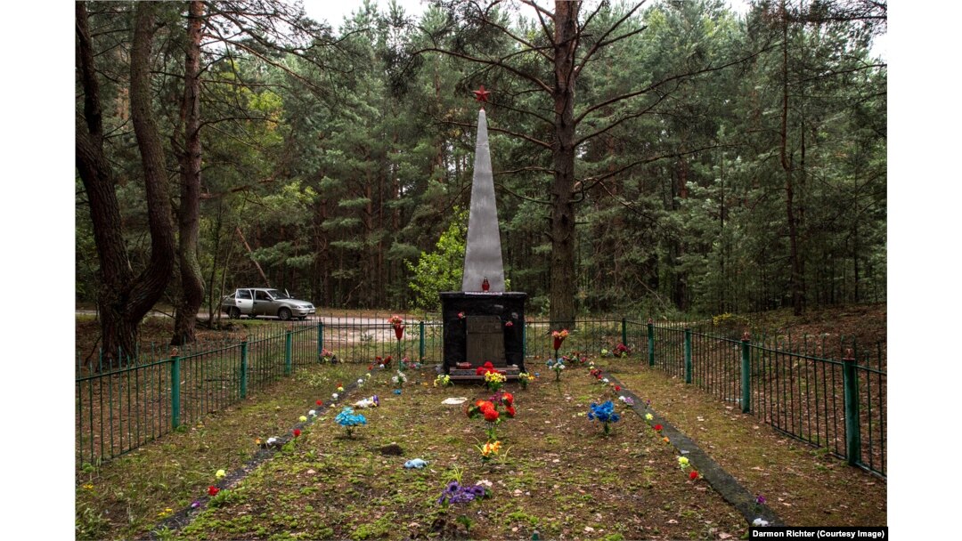 Novoshepelychi, Ukrajina. Obelisk s natpisom: „Ovdje su sahranjeni stanovnici susjednih sela koji su poginuli od fašističkih osvajača tokom Velikog otadžbinskog rata. 1941-1945. " Selo Novoshepelychi uglavnom je nestalo u šumi nakon što je bilo jako kontaminirano tokom nuklearne katastrofe, ali čini se da su spomenike dobro čuvali bivši stanovnici.