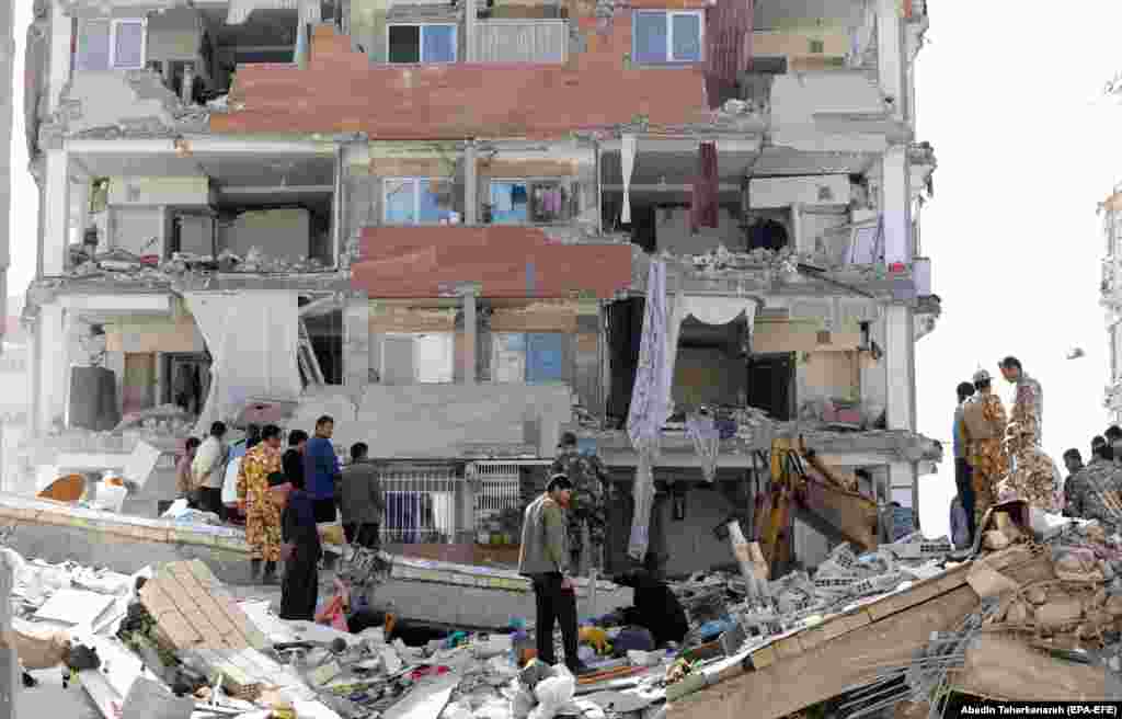 Iranian victims of the earthquake look for their belongings around the wreckage of their home in the city of Pole-Zahab in Kermanshah Province.