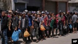 Palestinezët duke pritur pranë një qendre të GHF-së për shpërndarjen e ndihmës në Rripin e Gazës më 30 maj. 