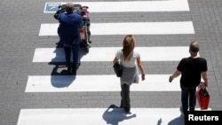 Udhëtarët duke ecur me bagazhet e tyre jashtë aeroportit Fiumicino, Itali, maj 2021.