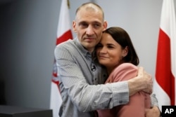 Білоруський опозиційний активіст Сергій Тихановський, звільнений з білоруської в'язниці, обіймає свою дружину Світлану Тихановську після пресконференції у Вільнюсі 22 червня 2025 року