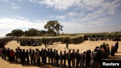 Muncitori egipteni din Libia așteptînd să fie admiși ca refugiați în Tunisia