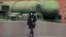 A woman wearing a face mask during a coronavirus lockdown walks past a Russian intercontinental ballistic missile launcher displayed at the Artillery Museum in St. Petersburg. 