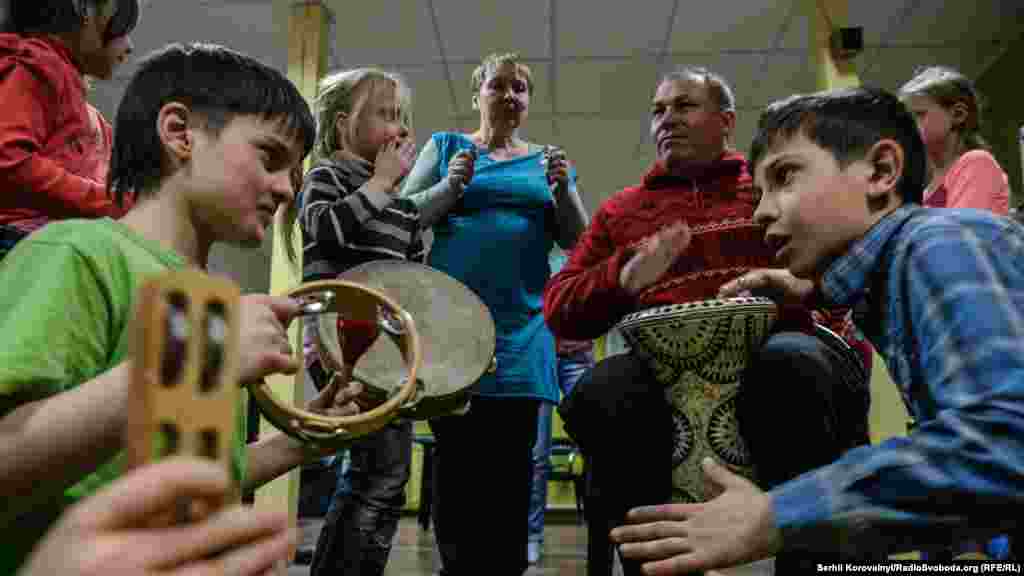 Діти та куратори б&#39;ють у барабани, намагаючись викликати сонячну погоду на завтрашній день