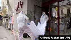 Forensic workers carry the body of Gholamreza Mansuri from the Duke Hotel in downtown Bucharest.