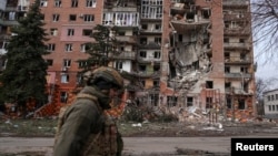 Украин сарбазы Ресей зымыраны қиратқан үйдің жанынан өтіп барады. Покровск, 6 наурыз.