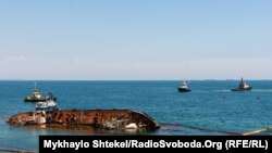 «Delfi» та три буксири поблизу нього 