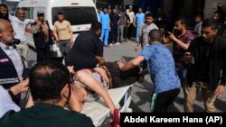 În imagine, un bărbat palestinian, rănit, într-un atac aerian israelian în centrul Fâșiei Gaza, este dus la spitalul Al-Aqsa Hospital din Deir al-Balah, sâmbătă, 17 mai. Imagine cu caracter ilustrativ.