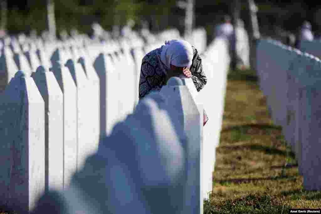 Боснийская мусульманка среди могильных камней жертв, убитых во время геноцида в Сребренице, у мемориала геноцида в Поточари, Босния и Герцеговина, 11 июля 2025 года. REUTERS/Amel Emric