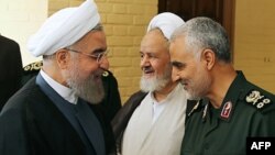 قاسم سلیمانی، فرمانده شاخه برون‌مرزی سپاه پاسداران (سمت راست)، حسن روحانی (چپ)