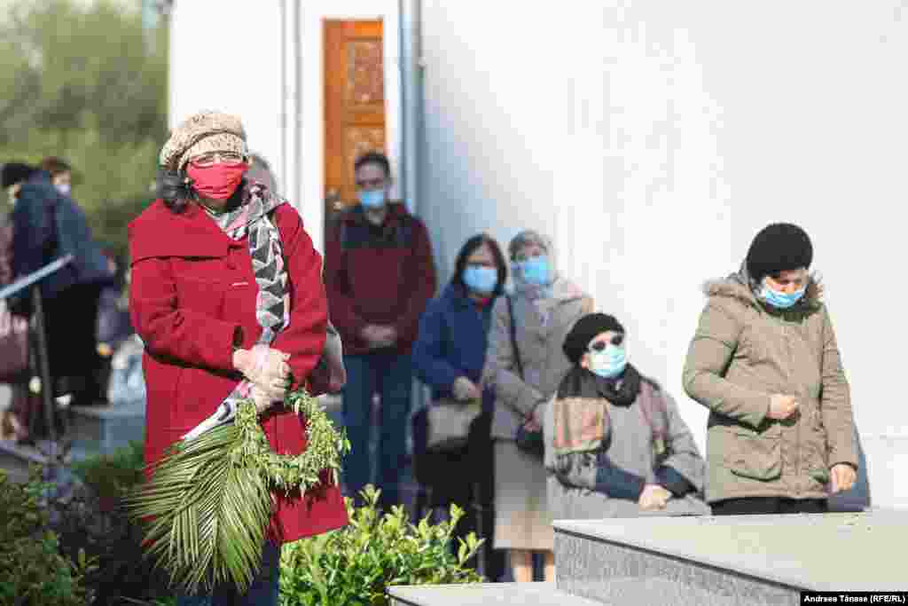 Slujba de Florii celebrată de credincioși în exteriorul Bisericii Sf. Arhangheli Mihail și Gavriil din București.
