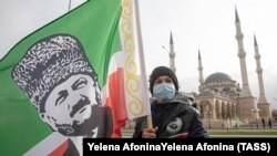 Un băiat cu steagul pe care este chipul primului președinte cecen, Ahmad Kadîrov (1951-2004) în așteptarea liderului cecen Ramzan Kadîrov, decembrie 2020
