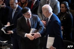 Президент США Джо Байден (справа) тисне руку спікеру Палати представників Майку Джонсону в Капітолії США у Вашингтоні 1 лютого 2024 року