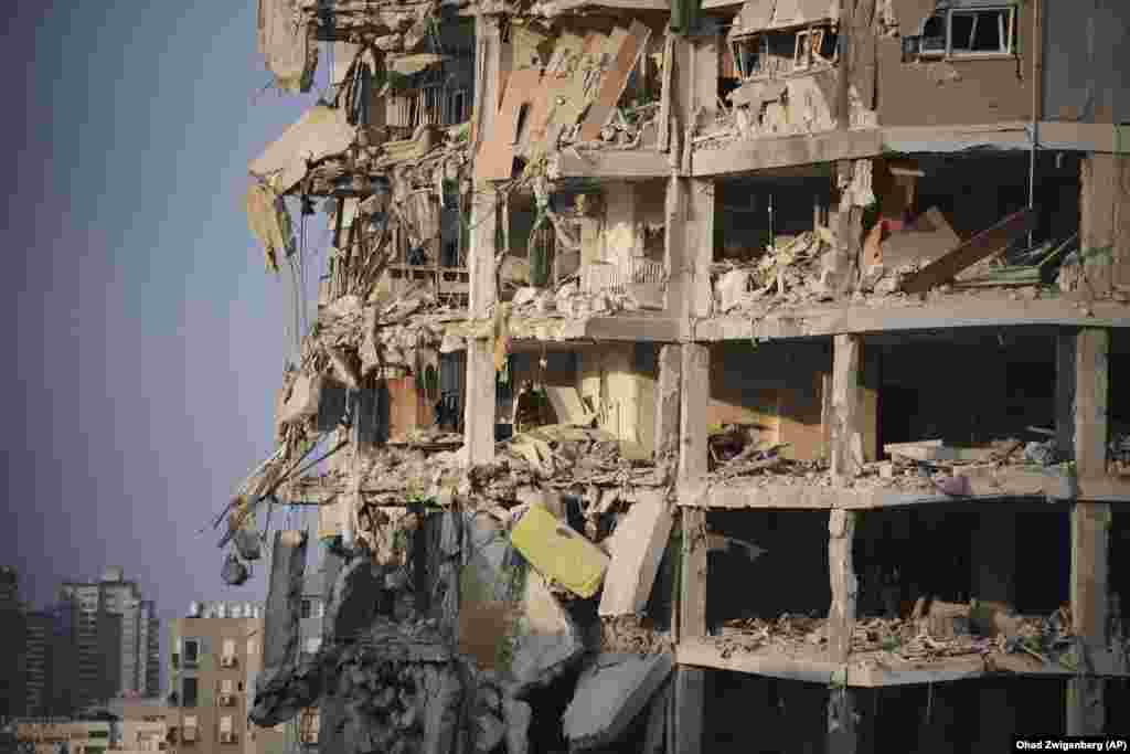 Forcat izraelite duke inspektuar një ndërtesë të shkatërruar, të goditur nga një raketë e lëshuar nga Irani, në Tel Aviv, më 15 qershor.